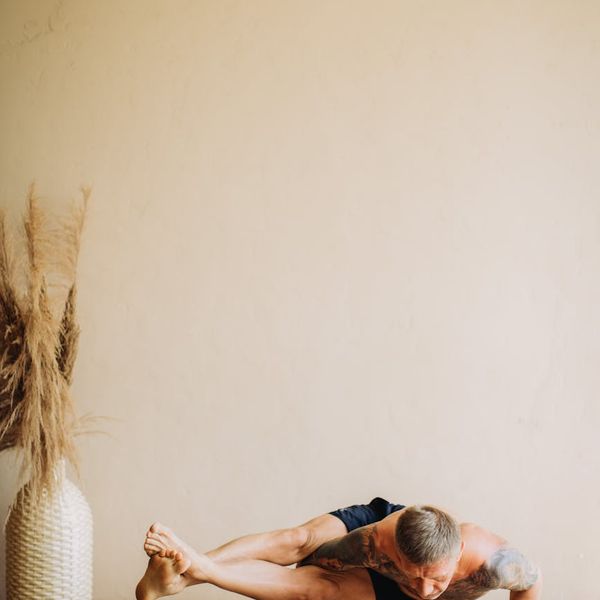 Man in a focused pose, demonstrating balance and control during a workout.